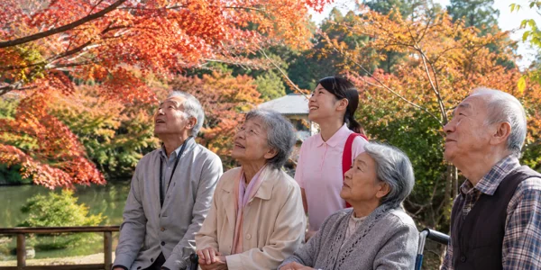 秋の紅葉を楽しむ高齢者と介護士