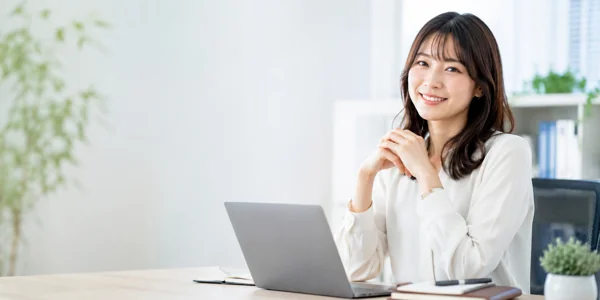 笑顔でパソコン作業する女性