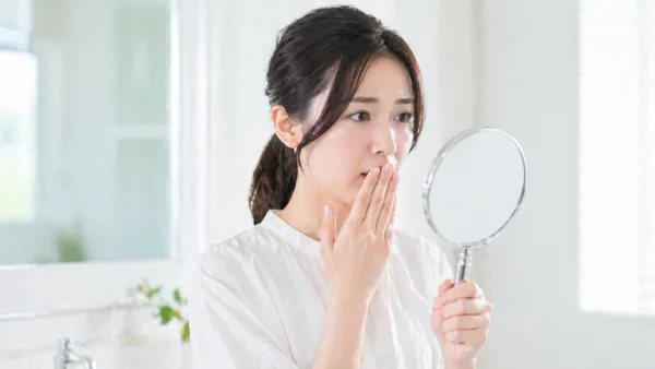 手鏡で肌を確認する女性