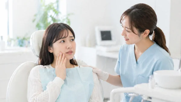 歯科診察で歯の痛みを訴える女性患者