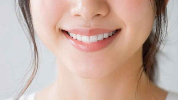 白い歯の笑顔・女性の口元アップ