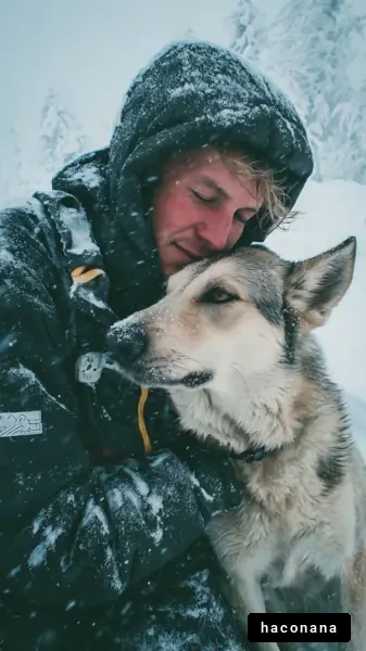 雪山で犬と寄り添う笑顔